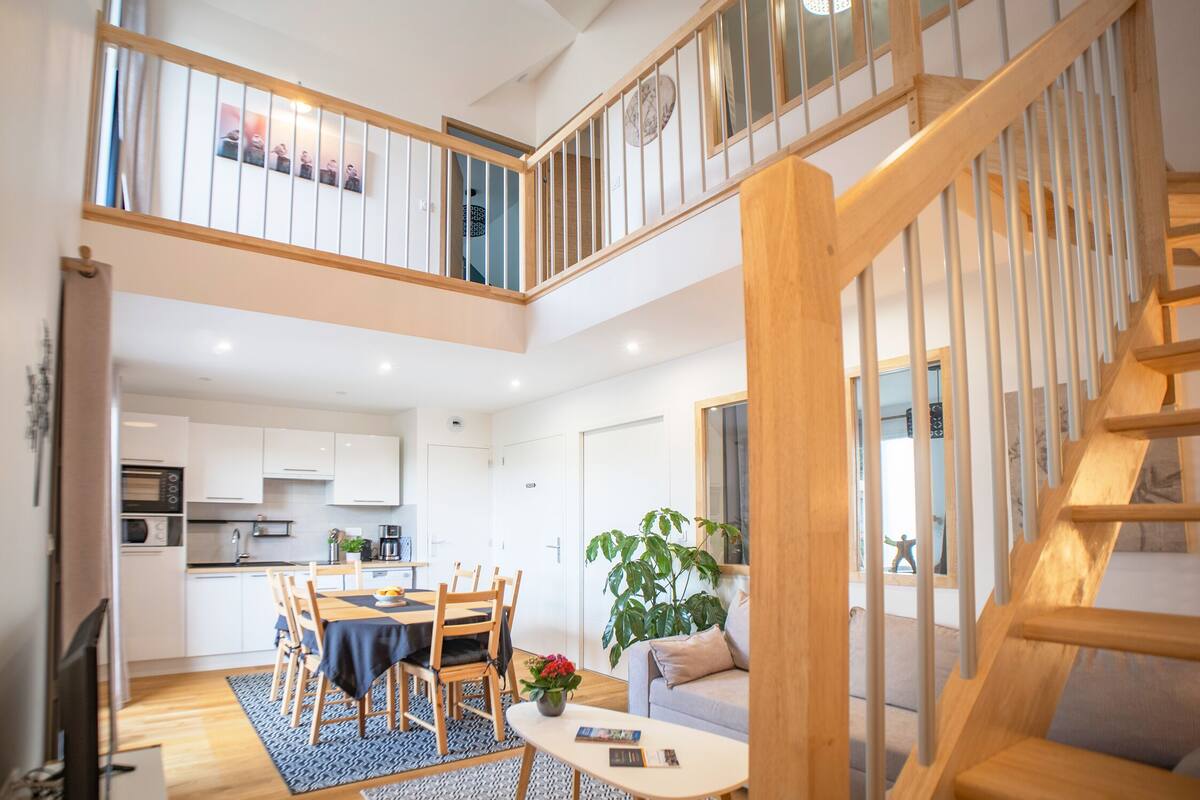 A modern apartment with a dining area, kitchen, and living space.