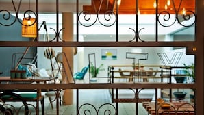 A modern interior with a dining area, visible through a decorative metal partition with the word "SALT" spelled out. - The Salty Lodge (Lagos)