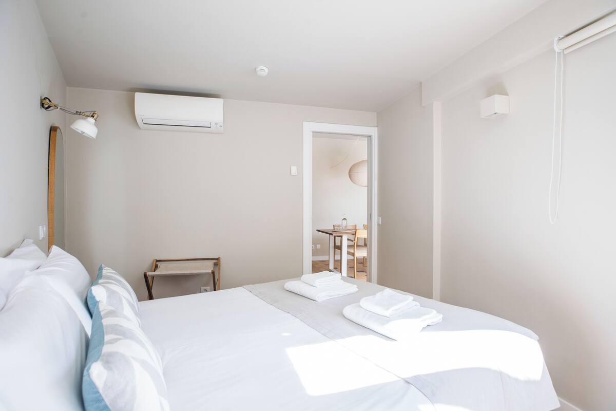 A hotel room with a bed, a desk, and a chair.
