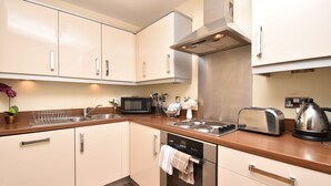 A modern kitchen with white cabinets, stainless steel appliances, and a wooden countertop. - The Hub - Milton Keynes - Instagram Heaven (Milton Keynes)
