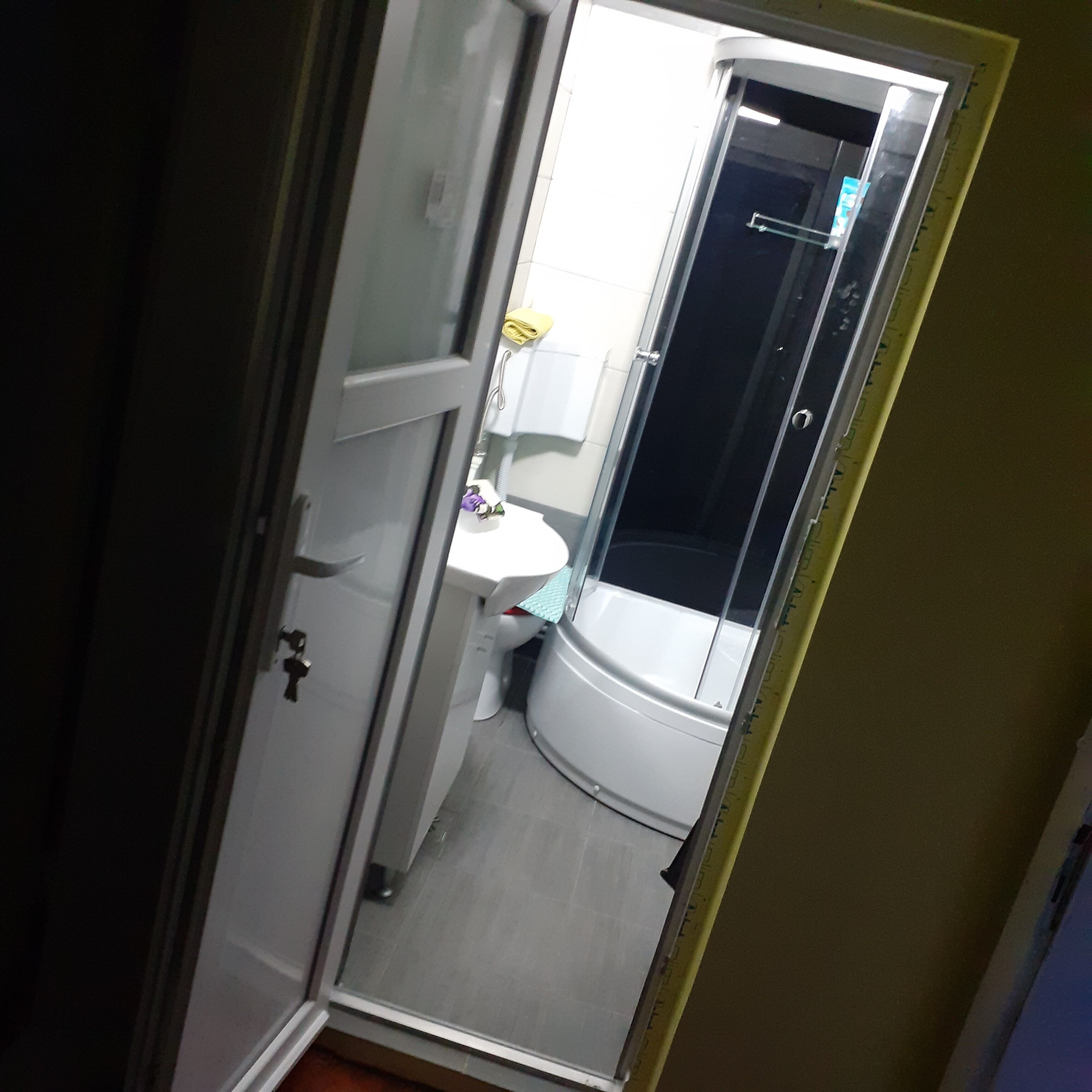 A bathroom with a toilet, a sink, and a shower stall.
