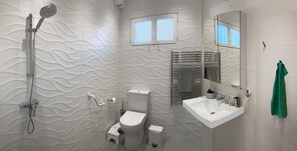 Un baño moderno con pared texturizada, ducha, inodoro, lavabo y espejo.