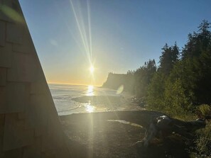 A beach with a sunset, trees, and a wooden structure. - A-Frame (Site 7) Shelter w/ Incredible Ocean View (Port Angeles)