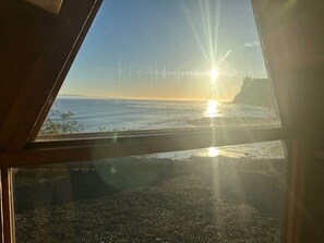 A view through a window with a beach and ocean in the background. - A-Frame (Site 7) Shelter w/ Incredible Ocean View (Port Angeles)