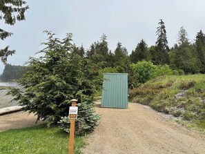 A gravel path leading to a green shed, with a sign indicating NW T-7. - A-Frame (Site 7) Shelter w/ Incredible Ocean View (Port Angeles)