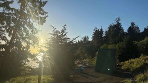 A campsite with tents and a green structure, surrounded by trees and a clear sky. - A-Frame (Site 7) Shelter w/ Incredible Ocean View (Port Angeles)