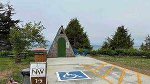 A wheelchair-accessible parking area with a handicap sign, a directional sign for Whiskey Creek Beach, and a T-5 trail marker.
