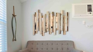 Ein Wohnzimmer mit grauem Sofa, einem Holztisch und einem Wandbild.