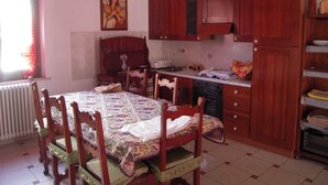 Une cuisine traditionnelle avec des meubles en bois, une table à manger avec des chaises et un radiateur.