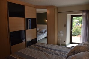 Une chambre à coucher avec un lit, un ventilateur et une vue sur l’extérieur.