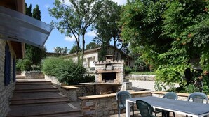A stone building with a brick fireplace, outdoor seating, and steps leading up to the entrance. - Old stone farmhouse in a quiet location with large heated pool. (lavaurette)