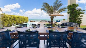 An outdoor dining area with a view of the ocean, a pool, and a lounge area. - Casa luxuosa a beira mar de Jacumã RN (Ceara-Mirim)