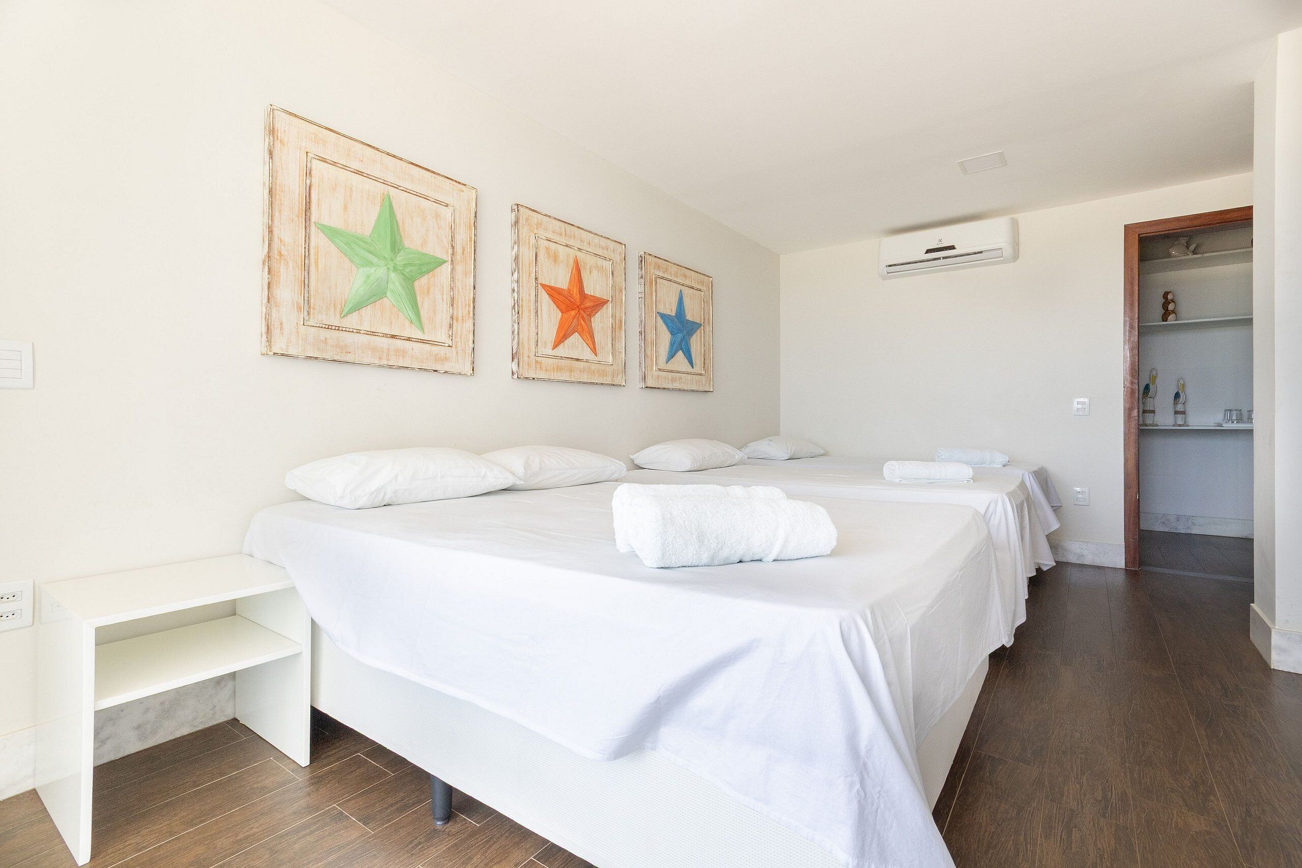 Una habitación de hotel con una cama grande, una mesita de noche y un armario.