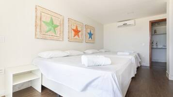 Una habitación de hotel con una cama grande, una mesita de noche y un armario.