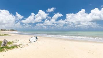 Une plage avec une tour de surveillance et une planche de surf sur le sable.