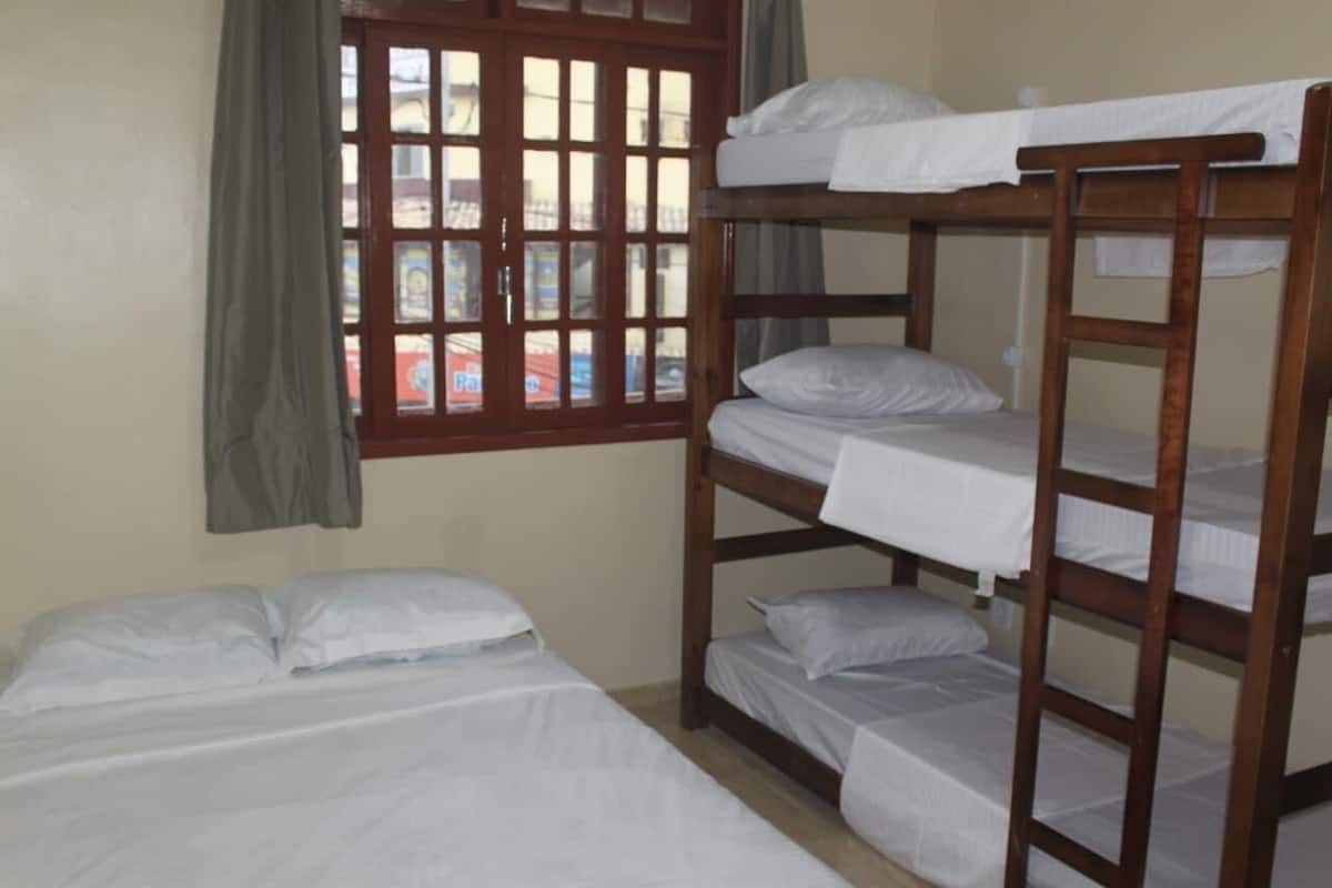 A bunk bed room with a window and curtains.