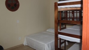 A single bunk bed room with a white mattress and a circular wall decoration. - Pe Na Areia Beach Hostel (Araruama)