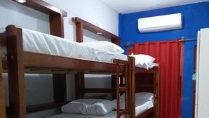 A bunk bed room with a wooden frame, white bedding, a red curtain, and an air conditioning unit on the wall. - Pe Na Areia Beach Hostel (Araruama)