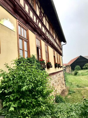 A traditional half-timbered building with multiple windows and flower boxes. - Restaurant & Hotel Frankenberger (Amt Wachsenburg)