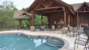 Un chalet en bois doté d’une piscine et d’un espace extérieur aménagé pour se détendre.