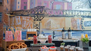 A table with pretzels, popcorn, and jars of spices.