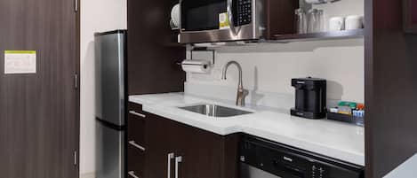 A modern kitchen with stainless steel appliances, a dishwasher, and a coffee maker.