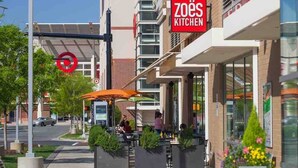 A modern urban street with a restaurant named 'zoës Kitchen' and a Target store. - Modern Cozy 1BR ◉ Gym ◉ Balcony ◉ Free Parking (Charlotte)