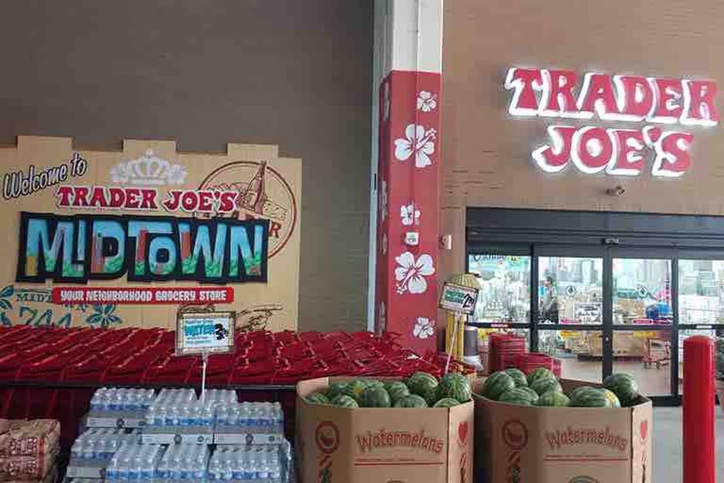 A grocery store interior with watermelons and bottled water on display.