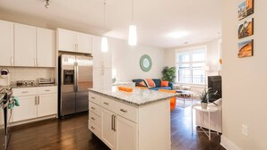 A modern kitchen with white cabinets, a stainless steel refrigerator, and a granite countertop. - Modern Cozy 1BR ◉ Gym ◉ Balcony ◉ Free Parking (Charlotte)