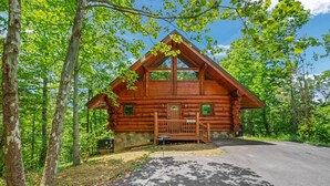 A log cabin with a front porch, surrounded by trees. - Star Views - 2BR/New Hot Tub/New Firepit/Grill/Sleeps 8 (Gatlinburg)