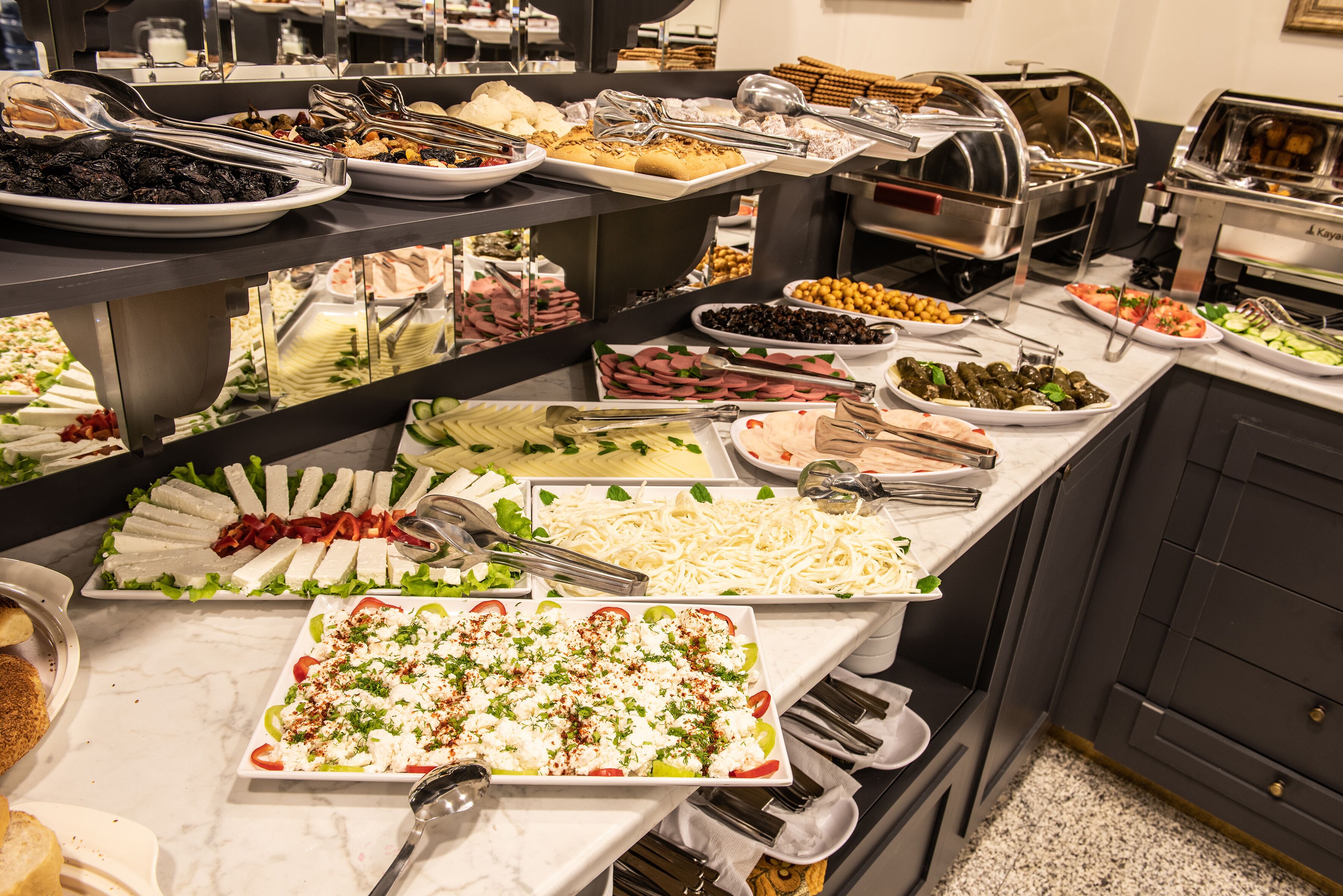 Een buffet met diverse keuzes, zoals salades, vleeswaren en kazen.