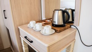 Un escritorio de madera con una tetera, dos tazas y una bandeja.