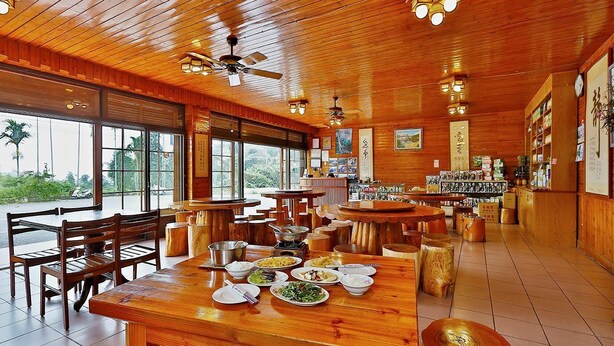 A restaurant with wooden interiors, multiple dining tables, and chairs. - Minzu Hotel (Lugu)