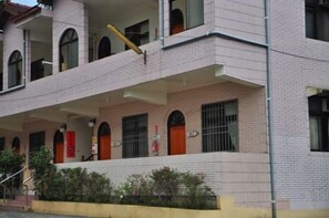 A two-story building with a flat roof, multiple windows, and a balcony. - Minzu Hotel (Lugu)
