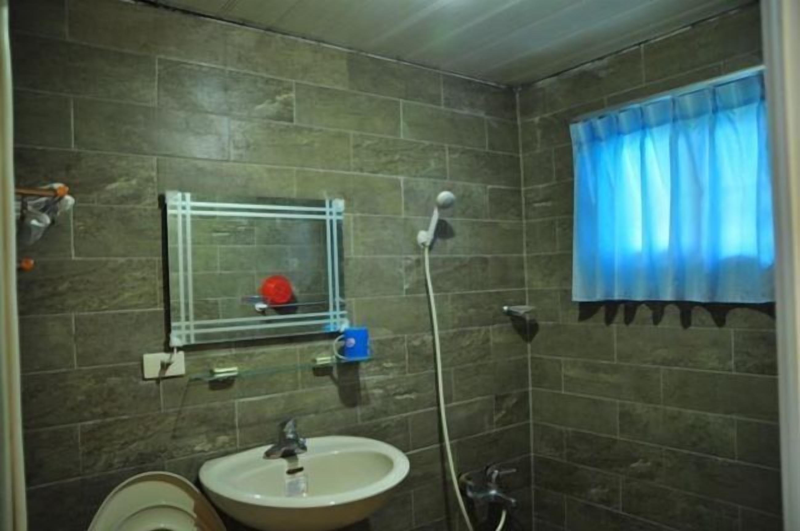 Un baño con lavabo, espejo y ducha.