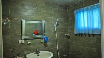 Un baño con lavabo, espejo y ducha.