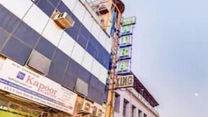 A building with a large glass facade and a sign for "Kapoor Plastics". - Aira Xing (New Delhi)