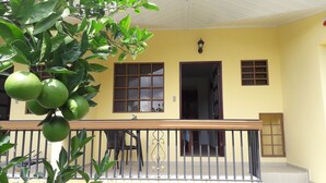 A yellow building with a balcony, a railing, and a window with a grid pattern. - Aparthotel Boquete (Boquete)