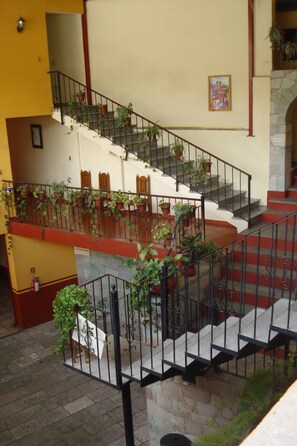 A multi-level staircase with metal railings, surrounded by potted plants. - Hotel Camino de Villaseca (Guanajuato)