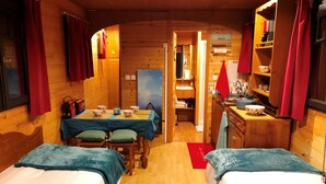 Un accogliente chalet in legno con due letti, un tavolo da pranzo e angolo cottura.