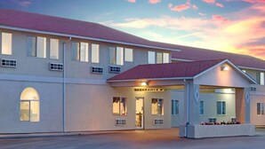 A hotel with a two-story structure, a covered entrance, and a sign indicating a clearance of 8 feet. - The Non-Smoking King Room (Vernal)