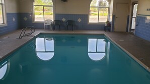 An indoor swimming pool with two diving boards, a tiled wall, and a door with a 'No Diving' sign. - The Non-Smoking King Room (Vernal)