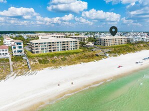 A coastal hotel with multiple buildings, a beach, and a clear sky. - HP 34E On the Gulf @ High Pointe | Lagoon Pool | Tennis & Pickleball Courts (High Pointe Resort)