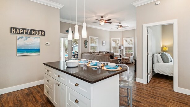 A kitchen with a central island, white cabinets, and a ceiling fan. - Spacious Retreat with Private Pool, Outdoor Oasis w/Firepit & Grill, and 8 Bikes (Seacrest Beach West)