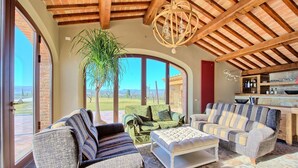 Un salon spacieux doté d’une grande fenêtre, d’un plafond en bois et offrant une vue sur l’extérieur.
