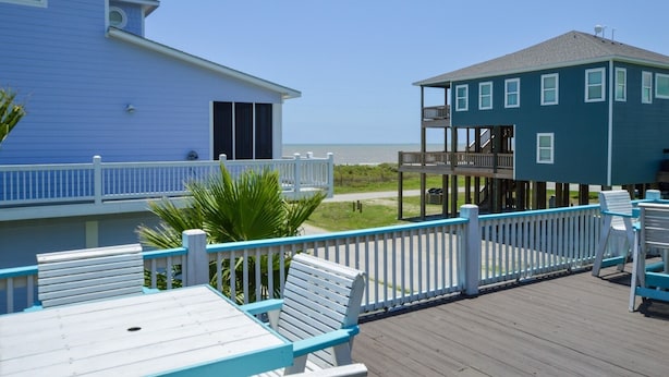 A two-story beachfront property with a balcony and outdoor seating area. - Sum Beach- Great Beach Views-4 bedroom 3 bath home sleeps 13. (Crystal Beach)
