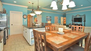A kitchen with a dining area, featuring a wooden table, chairs, and a chandelier. - Sum Beach- Great Beach Views-4 bedroom 3 bath home sleeps 13. (Crystal Beach)