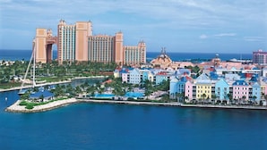 A coastal resort with a large hotel featuring multiple towers and colorful buildings along the beachfront.