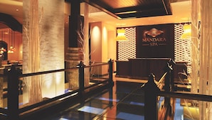 A modern lobby with a reception desk, a glass railing, and a decorative wall with vertical elements.