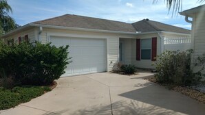 A single-story house with a garage, a front porch, and a driveway. - Beautiful Villa in the Heart of Florida's Friendliest Active Adult Community (The Villages)